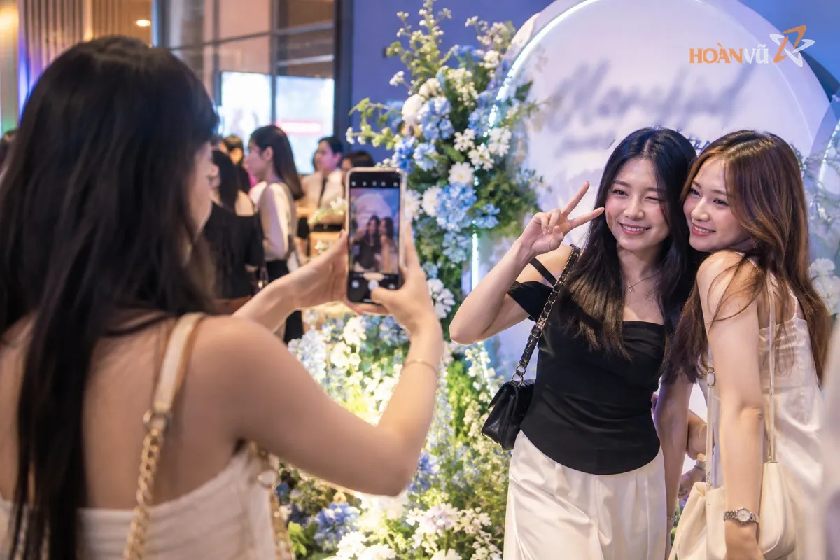 Khách tham dự chụp ảnh tại góc check-in của sự kiện bằng điện thoại, đăng lên mạng xã hội